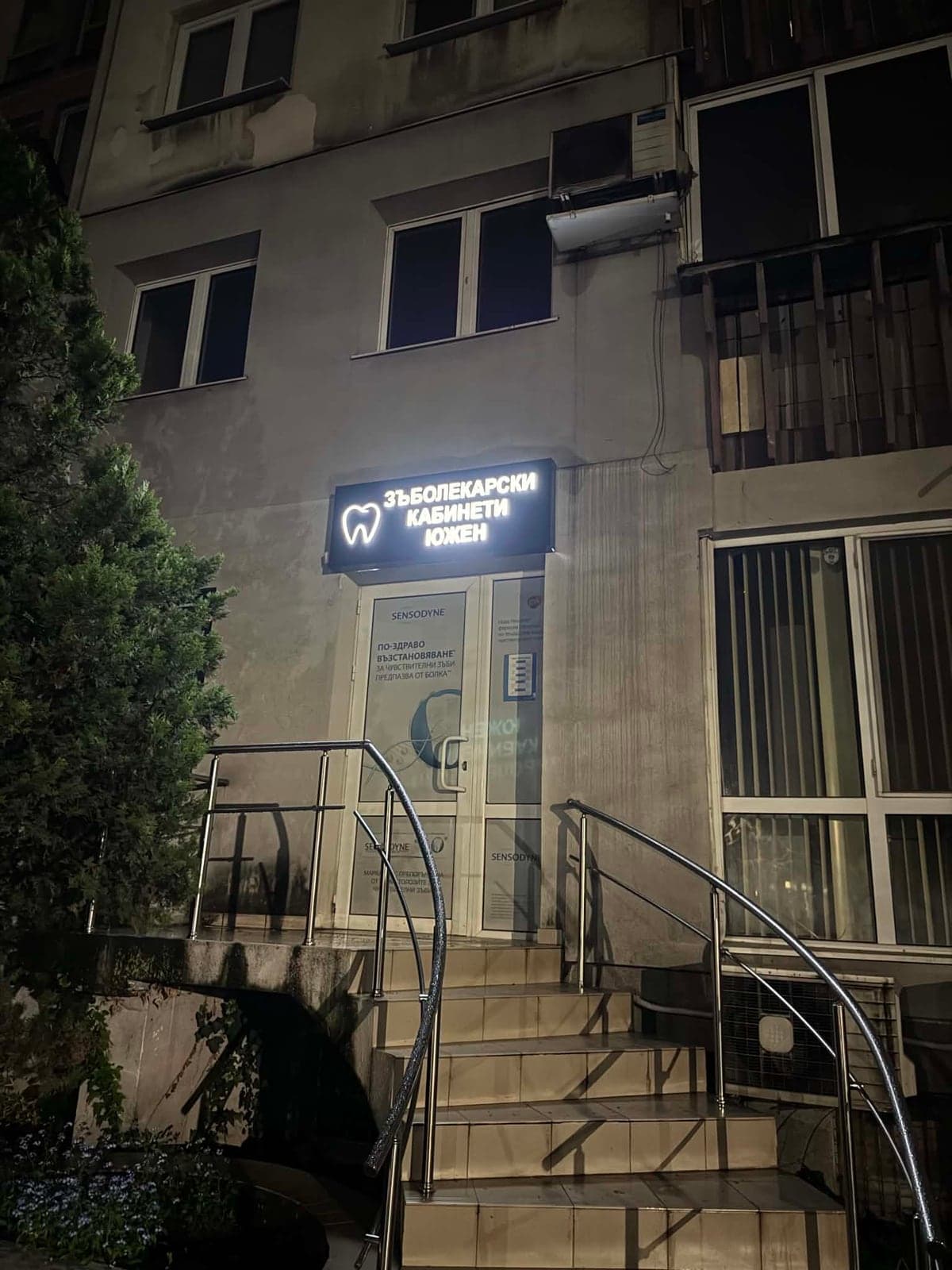 The T&Co Dental entrance at 34 Dame Gruev St. at night: steps with a handrail and an illuminated sign